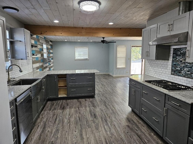 kitchen with dark wood-type flooring, backsplash, light stone counters, and stainless steel appliances