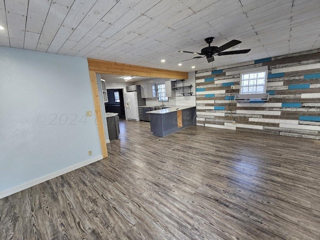 kitchen with kitchen peninsula, ceiling fan, a kitchen bar, white fridge with ice dispenser, and dark hardwood / wood-style flooring