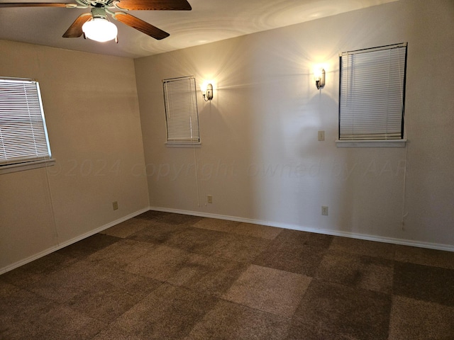 carpeted spare room with ceiling fan