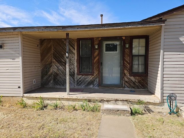 view of exterior entry featuring covered porch