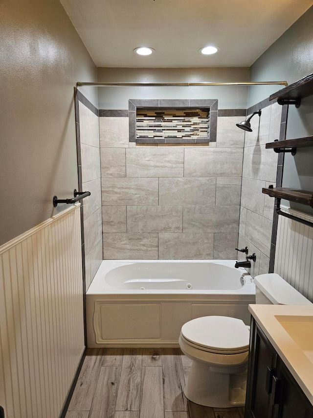 full bathroom featuring toilet, tiled shower / bath combo, vanity, and hardwood / wood-style floors