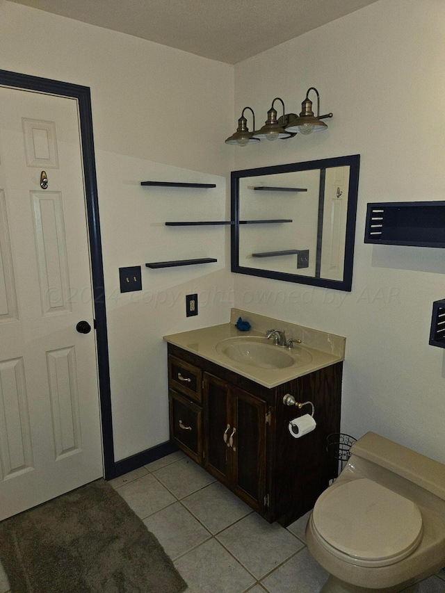 bathroom featuring vanity, tile patterned flooring, and toilet