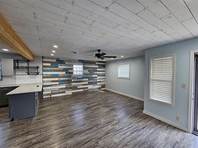 unfurnished living room with dark hardwood / wood-style flooring and ceiling fan