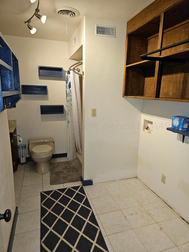 bathroom with a shower with shower curtain, tile patterned floors, toilet, and vanity