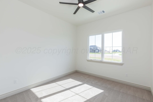 unfurnished room featuring baseboards, visible vents, light colored carpet, and ceiling fan