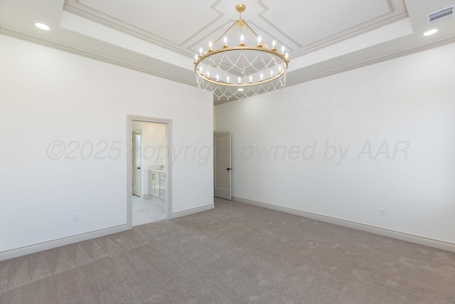 spare room featuring a tray ceiling, carpet flooring, visible vents, a notable chandelier, and crown molding