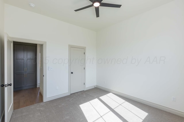unfurnished bedroom featuring carpet, baseboards, and ceiling fan