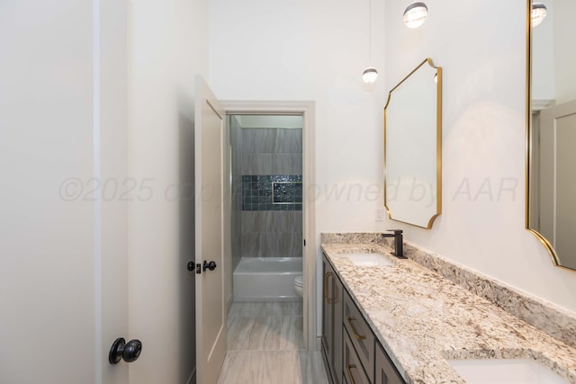 bathroom with a sink, double vanity, and toilet