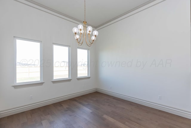 empty room with an inviting chandelier, crown molding, wood finished floors, and baseboards