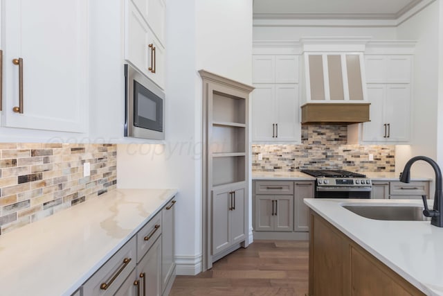 kitchen with stainless steel gas stove, a sink, built in microwave, and backsplash