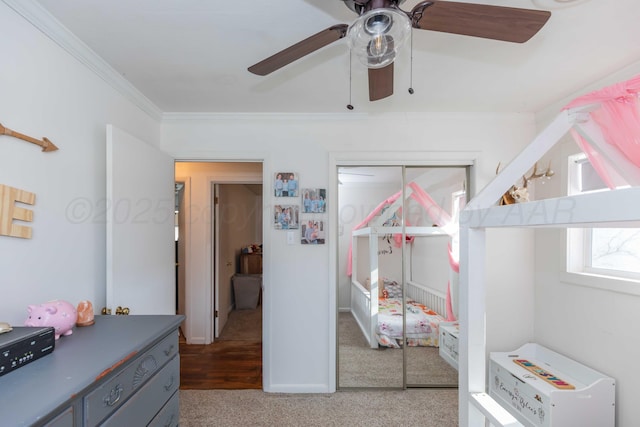 bedroom featuring a closet, light colored carpet, crown molding, and ceiling fan