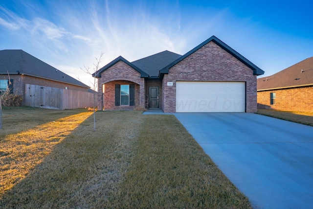 ranch-style home with a garage, brick siding, fence, concrete driveway, and a front yard