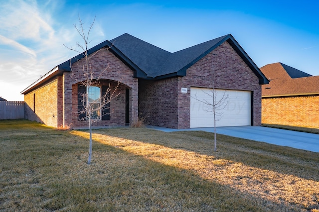 ranch-style house with an attached garage, brick siding, concrete driveway, roof with shingles, and a front lawn