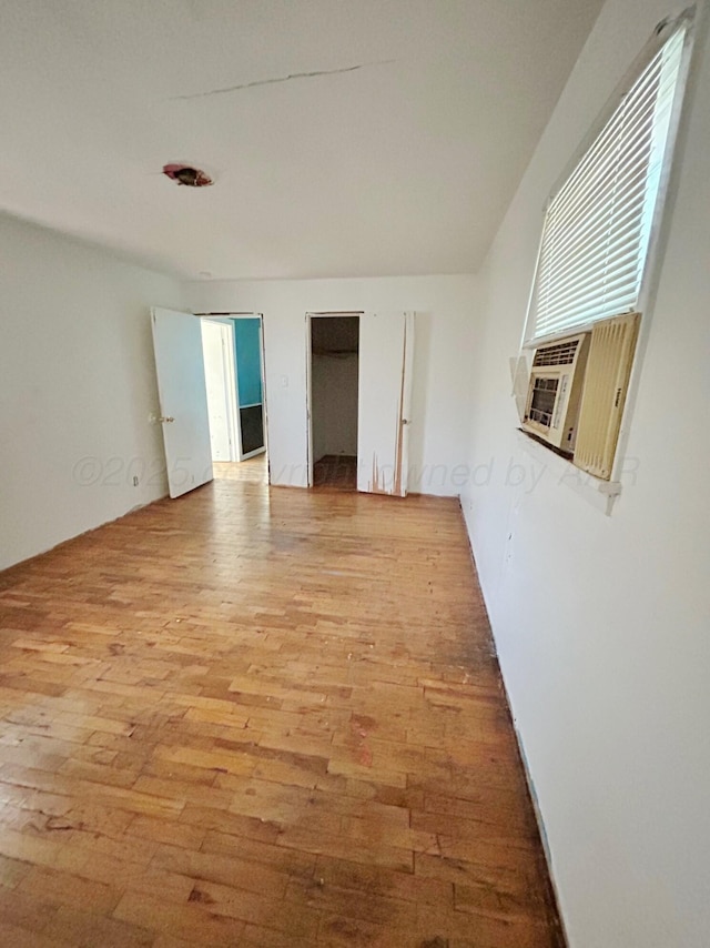 empty room with cooling unit and light hardwood / wood-style flooring