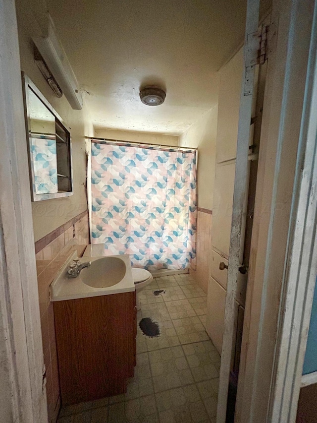 bathroom featuring vanity, tile walls, a shower with shower curtain, and toilet