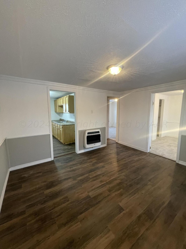 401 N Fairmont St, Amarillo, TX 79106 - unfurnished living room featuring heating unit, a textured ceiling, dark wood-style floors, baseboards, and a sink