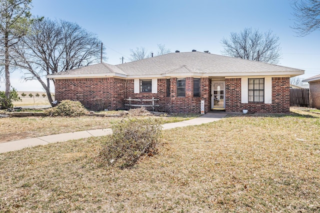 ranch-style house with brick siding, fence, and a front yard