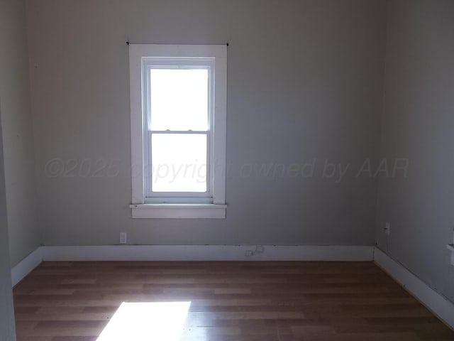 unfurnished room with wood finished floors