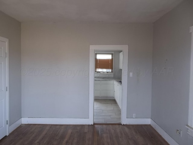 unfurnished bedroom featuring baseboards and wood finished floors