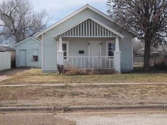 bungalow-style home featuring covered porch and fence