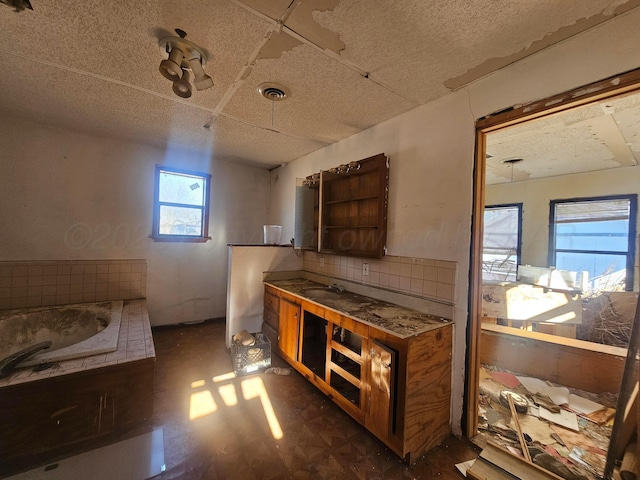 full bath featuring visible vents, backsplash, vanity, and a bath