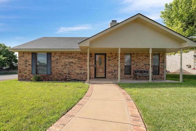 6701 Admiral Ct, Amarillo, TX 79124 - view of front facade featuring a front yard, brick siding, a chimney, and covered porch