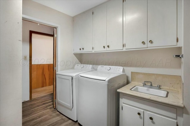 laundry area featuring cabinets, dark hardwood / wood-style flooring, separate washer and dryer, and sink