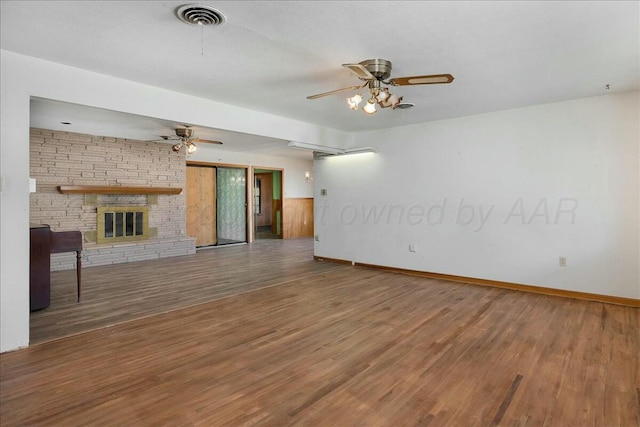 unfurnished living room with a stone fireplace and hardwood / wood-style floors