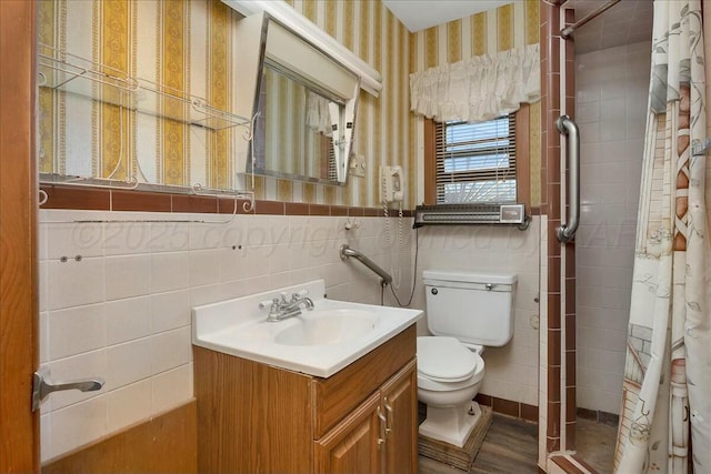 bathroom featuring hardwood / wood-style floors, toilet, vanity, tile walls, and a shower with shower curtain