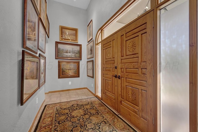 hallway with baseboards and a textured wall