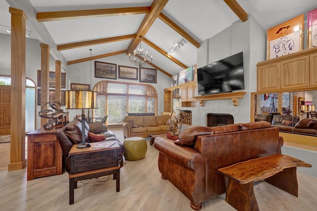 living room featuring a notable chandelier, beam ceiling, light wood finished floors, a fireplace, and high vaulted ceiling