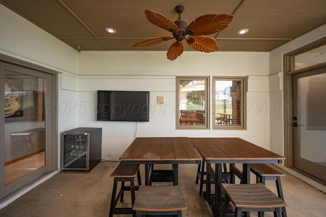 view of patio with wine cooler, outdoor dining space, and ceiling fan