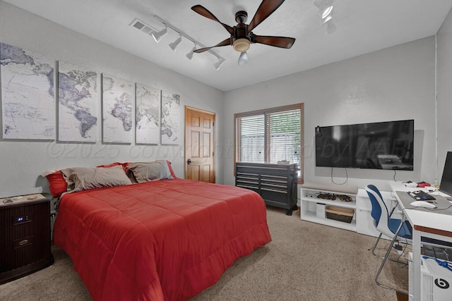 carpeted bedroom with visible vents, a ceiling fan, and rail lighting