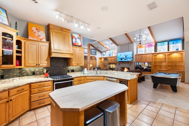 kitchen with decorative backsplash, stainless steel appliances, a kitchen island, visible vents, and a peninsula