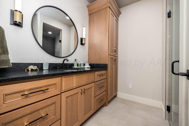 bathroom featuring baseboards, a shower stall, and vanity