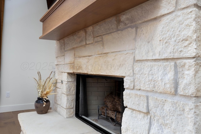 room details with wood finished floors, baseboards, and a fireplace