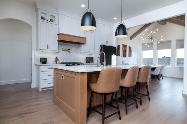 kitchen with recessed lighting, light countertops, light wood-style flooring, tasteful backsplash, and custom exhaust hood