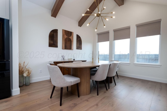 dining space featuring lofted ceiling with beams, plenty of natural light, an inviting chandelier, and light wood-style floors