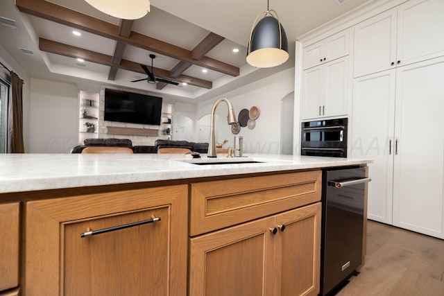 kitchen with coffered ceiling, wood finished floors, a ceiling fan, a sink, and beamed ceiling