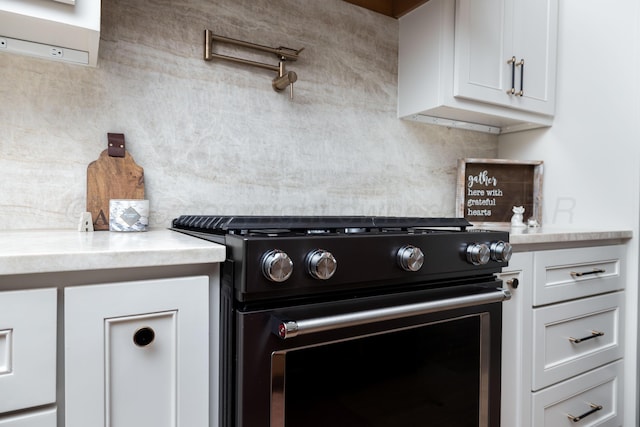 kitchen with white cabinets, black gas range oven, and light countertops
