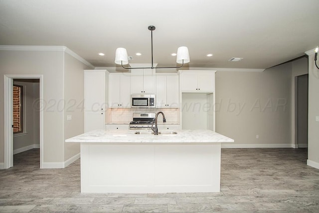 kitchen with appliances with stainless steel finishes, a sink, backsplash, and light stone countertops