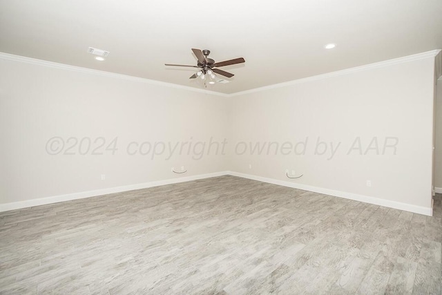 unfurnished room featuring baseboards, crown molding, visible vents, and wood finished floors