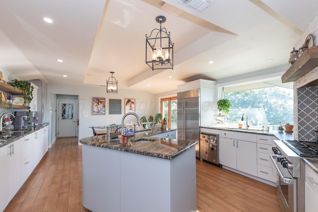 2 Altamira St, Borger, TX 79007 - kitchen featuring high quality appliances, open shelves, a sink, an island with sink, and dark stone counters