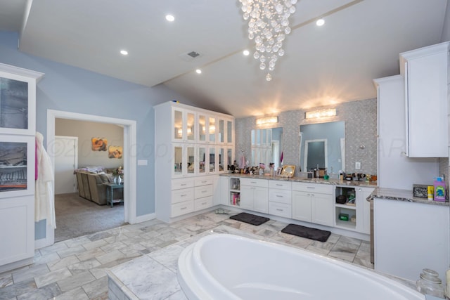 2 Altamira St, Borger, TX 79007 - full bathroom featuring vaulted ceiling, a bath, vanity, and recessed lighting