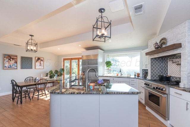 2 Altamira St, Borger, TX 79007 - kitchen featuring high end appliances, light wood-type flooring, a sink, white cabinets, and dark stone counters