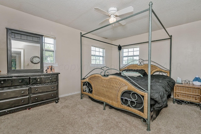 carpeted bedroom with ceiling fan and a textured ceiling