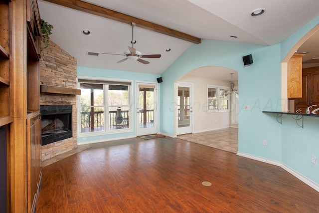 103 N Timbercreek Dr, Amarillo, TX 79118 - unfurnished living room with lofted ceiling with beams, arched walkways, a ceiling fan, and a fireplace
