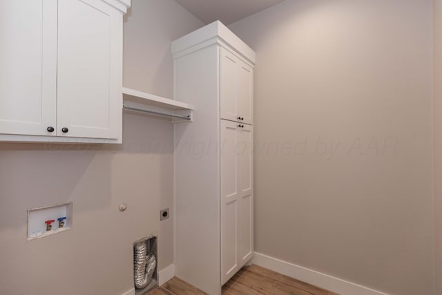 laundry area featuring baseboards, light wood-type flooring, electric dryer hookup, cabinet space, and washer hookup