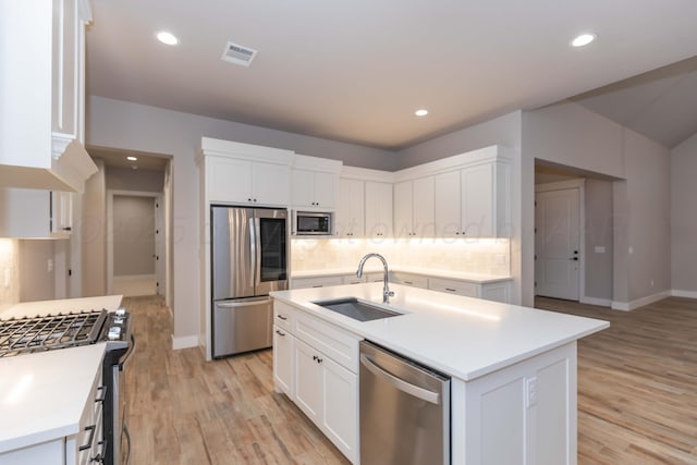 kitchen featuring a sink, baseboards, decorative backsplash, and stainless steel appliances