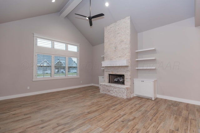 unfurnished living room with ceiling fan, a fireplace, high vaulted ceiling, beamed ceiling, and light wood finished floors